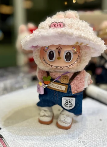 Labubu Nº 05: cream bucket hat, denim overalls and crystals on the cheeks.