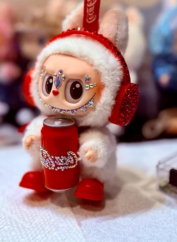 Labubu Nº 11: red crystal ear muffs, a sparkling cola can and red boots.